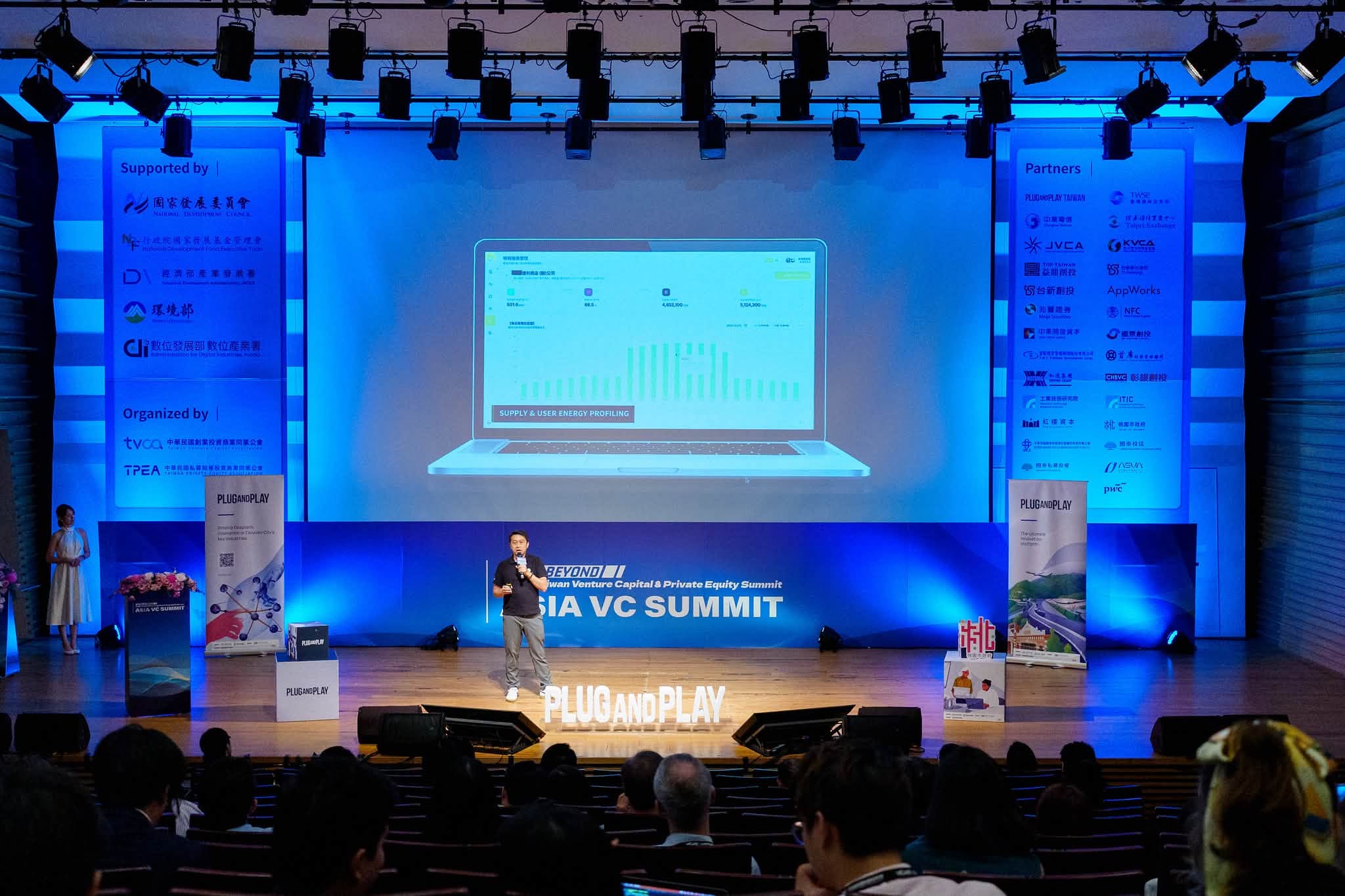 황웨이저 박사가 ASIA VC SUMMIT 무대에서 발표하며, 현장에서 Plug and Play와 KiWi 전시물을 볼 수 있습니다.